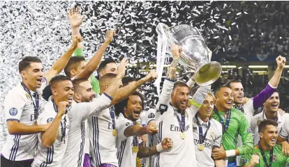  ??  ?? Real Madrid players quickly changed from their purple away kit to their white shirts after the match to lift the Champions League trophy