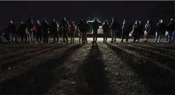  ?? PHOTOS BY GREGORY BULL — THE ASSOCIATED PRESS ?? Migrants wait to be processed to seek asylum after crossing the border into the United States near Yuma, Ariz., Friday.