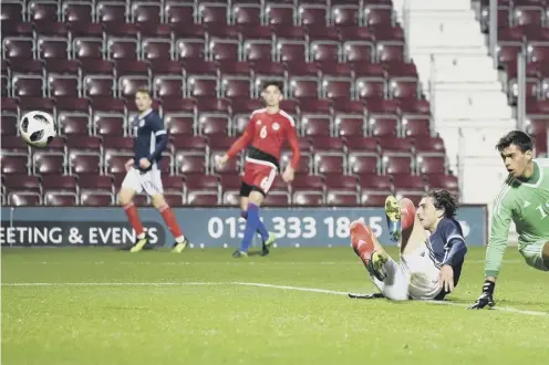  ??  ?? 0 Fraser Hornby, grounded, watches his shot head towards the Andorra net as he completes his hat-trick in Scotland’s 3-0 victory.