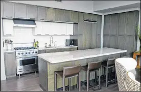  ??  ?? The sleek kitchen in the Atlanta condo offers ample space for restaurate­ur and homeowner Ross Jones to prepare a meal. “We have a long countertop. That to me is heaven for cooking. You have plenty of space to do your chopping and dicing,” she said.