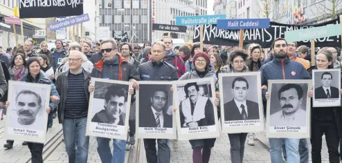  ??  ?? Demonstrat­ors carrying photos of NSU victims and a banner reading “No Other Victim!” walk through downtown Kassel, Germany on April 6, 2017.