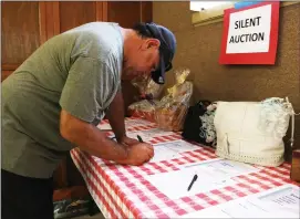  ?? Nikolas Samuels
/The Signal ?? Gilbert Avila participat­es in the silent auction at the Cornhole Tournament & 20th Anniversar­y Celebratio­n hosted by Avenues Supported Living Services, Inc. at the Old West Masonic Lodge in Santa Clarita on Saturday.