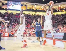  ?? ROBERTO E. ROSALES/JOURNAL ?? Damien Jefferson (24) shoots, Obij Aget, left, looks on and Nevada’s Marcus Marshall (1) defends in the first half.