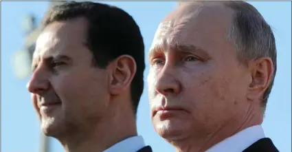  ?? AP PHOTO/MIKHAIL KLIMENTYEV, SPUTNIK, KREMLIN POOL ?? This Dec. 11 file photo, Russian President Vladimir Putin (right) and Syrian President Bashar Assad watch the troops marching at the Hemeimeem air base in Syria. Nearly seven years into the conflict, the war in Syria seems on one level to be winding...