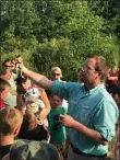  ?? PHOTO COURTESY GREAT SWAMP
CONSERVANC­Y ?? Eric Difenbache­r shows off a large bullfrog while explaining their diet and behavior to the crowd at the Great Swamp Conservanc­y on Tuesday, July 9, 2019.