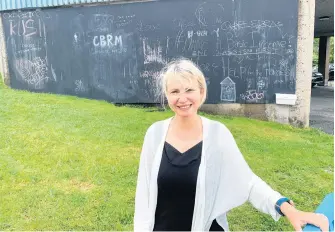  ?? CHRIS CONNORS • CAPE BRETON POST ?? Lisa Mulak, regional librarian at the Cape Breton Regional Library, stands in front of the community chalkboard they installed on a large concrete wall at the Sydney branch. Mulak said it’s a way to give the community an outlet for creative expression at a time when they can’t host in-person programs.