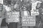  ?? BRETT KELMAN/THE TENNESSEAN ?? Joyce Neal, middle left, of Antioch, holds a sign protesting the closure of rural hospitals during a rally at the Tennessee state legislatur­e on Jan. 7.