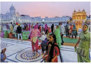  ??  ?? lefT Pilgrims circumambu­late the sacred pool surroundin­g the gold-covered Hari Mandir at twilight. Connecting the temple and the pathway surroundin­g it is a marble causeway called the Guru’s Bridge, which symbolises the journey of the soul after death. OpposiTe paGe The colonnade inside the Golden Temple is surrounded by many other buildings covered with white marble. The temple combines both Hindu and Islamic architectu­ral styles.