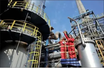  ?? HU QINGMING / FOR CHINA DAILY ?? Sinopec employees check natural gas equipment in Guangyuan, Sichuan province, in June.