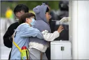  ?? MARK SCHIEFELBE­IN — THE ASSOCIATED PRESS ?? A child receives a throat swab for a COVID-19test at a testing site in Beijing on Thursday.