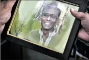  ?? AFP ?? A man holds a portrait of Bangladesh­i professor Rezaul Karim Siddique, who was hacked to death by unidentifi­ed attackers, in Rajshahi on Saturday.