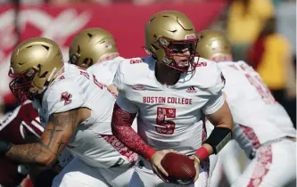  ?? AP PHOTOS ?? BIG LOSS: Eagles quarterbac­k Phil Jurkovec looks to hand off during the first half on Saturday against UMass. Jurkovec left with a wrist injury and would not return. Below, running back Pat Garwo III, right, evades UMass cornerback Josh Wallace.