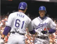  ?? Eric Risberg / Associated Press 2000 ?? The Dodgers’ Kevin Elster is congratula­ted by Chan Ho Park after hitting Pac Bell Park’s first homer.