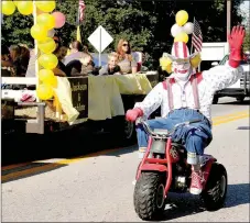  ??  ?? Rainbo the Clown played by Mitch Whitehouse of Prairie Grove entertains during the 2016 Clotheslin­e Fair parade.