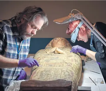  ??  ?? PAINSTAKIN­G: Dr Mark Hall and Anna Zwagerman work on the mummy.