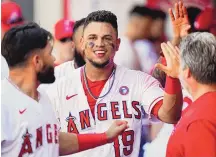  ?? ASHLEY LANDIS/ASSOCIATED PRESS ?? Juan Lagares (19) of the Los Angeles Angels celebrates in the dugout after hitting a go-ahead double during the ninth inning. Kurt Suzuki and Jose Rojas scored to win the game 6-5.