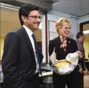  ?? PETER LEE, RECORD STAFF ?? Attorney General Yasir Naqvi, left, and Kitchener Centre MPP Daiene Vernile take a closer look at a dish being prepared in the kitchen at the House of Friendship in Kitchener on Monday.