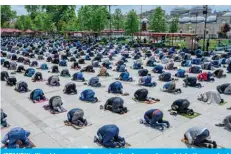  ?? – AFP ?? ISTANBUL: Worshipper­s wearing protective facemasks maintain the required social distance during Friday prayers outside the Fatih Mosque, now open for prayers.