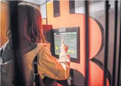  ?? BLOOMBERG ?? A customer uses a bitcoin ATM at a kiosk in Barcelona on Feb 23.