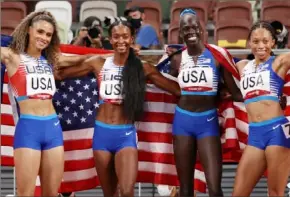  ?? Getty Images photos ?? Allyson Felix, left, passes the baton to Dalilah Muhammad, left. Felix, far right, then celebrates gold with Sydney McLaughlin, Muhammad and Athing Mu.