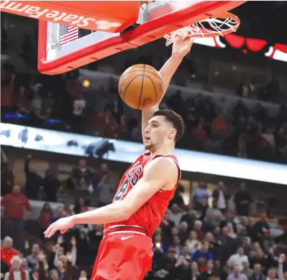  ??  ?? The Bulls’ Zach LaVine dunks the ball to break a tie after stealing an inbounds pass in the closing seconds.