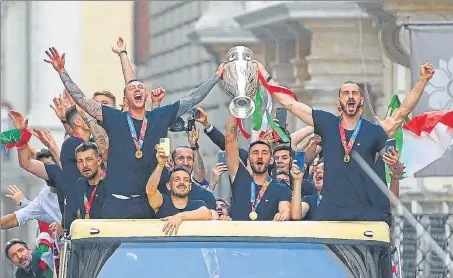  ?? AFP ?? Players of Italy's national football team parade with the UEFA EURO 2020 trophy on a bus in Rome on Monday after beating England in the final on Sunday.