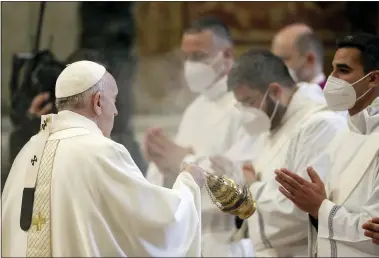  ?? ANDREW MEDICHINI — THE ASSOCIATED PRESS ?? Pope Francis spreads incense April 25, during a ceremony to ordain nine new priests, standing in front of him and wearing face masks to curb the spread of COVID-19, inside St. Peter’s Basilica, at the Vatican.