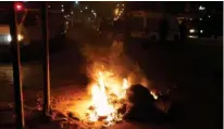  ?? - Reuters ?? STIR: Police vehicles stop in front of burning tires set up by protesters during demonstrat­ions against rising prices and tax increases, in Tunis, Tunisia, January 8, 2018.