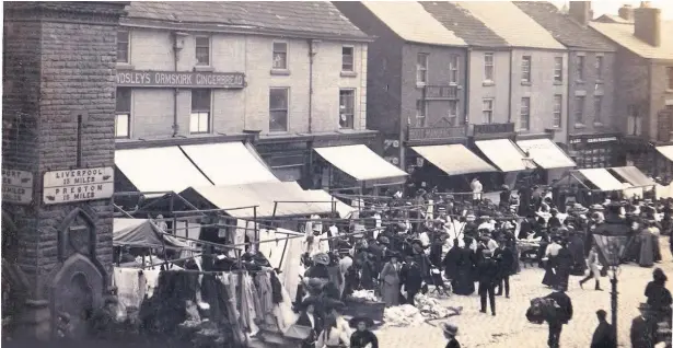  ?? Mawdesley’s shop, stood at No 1 Aughton Street, seen behind the clock tower on a busy market day ??