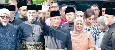  ?? Associated Press ?? ↑
Muhyiddin Yassin (centre) waves as he prepares to leave his house for the palace for the swearing-in ceremony in Kuala Lumpur on Sunday.