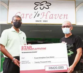  ??  ?? Helping hand: Nelson (left) presenting a mock cheque for RM20,000 to Thhm at the home in Taman Bukit Rinting, Pasir Gudang.