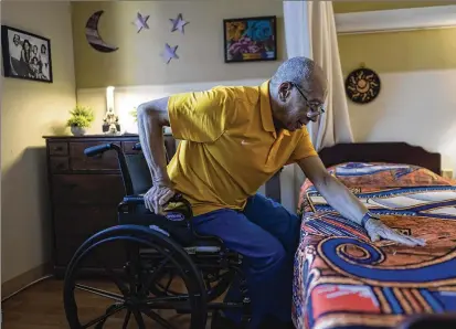  ?? PHOTOS BY WONG MAYE-E/AP ?? Alex Morisey lifts himself out of his wheelchair in Philadelph­ia. He hasn’t been outside since before the new year dawned, can’t hear a soft Mexican ballad over the thunder of his roommate’s TV, and when he checks his bank account, there isn’t enough to order a replacemen­t for his tattered pants.