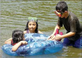 ?? Photo by Randy Moll ?? GG, 5, Sheyla, 9, and Joshua Gonzales, 12, all of Bentonvill­e, enjoyed a cool dip at Crystal Lake in Decatur on a hot afternoon, July 20.