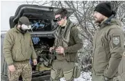  ?? /Reuters ?? Tech war: A Ukrainian serviceman of the ‘Achilles’ Attack Drone Battalion with the call sign ‘Darwin’, 20, shows his brothers-in-arms how to operate a first-person view drone.