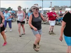  ?? SARAH GORDON THE DAY ?? Sharon Vasta, center, a student at Dance Country, participat­es in a beginners country line dancing class at the Custom House Stage during the final day of Sailfest on Sunday.