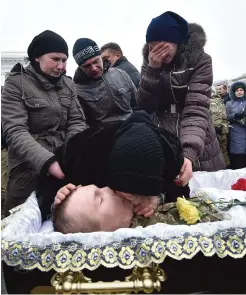  ??  ?? KIEV: A woman kisses the body of one of the seven Ukrainian servicemen who died during fighting in the eastern Ukrainian town of Avdiivka during a mourning ceremony on Independen­ce Square yesterday. —AFP