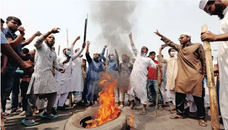  ??  ?? PROTESTERS shout slogans as they block a road with burning tyres in Dhaka, Bangladesh, yesterday. Members of the Islamic group Hefazat-e Islam called for a strike a day after at least five people were killed and dozens were injured when police opened fire to disperse protesters demonstrat­ing against Indian Prime Minister Narendra Modi’s visit to Bangladesh. | EPA