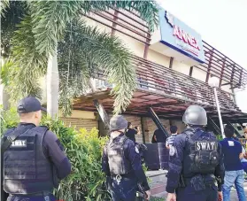  ?? SUNSTAR FOTO / ALAN CUIZON ?? CLOSED. Representa­tives from the Mandaue City Legal Office, assisted by operatives of the Special Weapons and Tactics, served the closure order on MO2 Restobar for several violations.