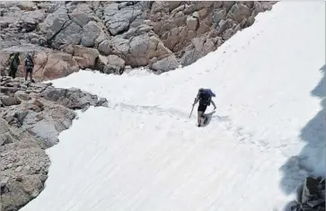  ?? Jake Gustafson Via Associated Press ?? WESLEY TILS crosses a snow-covered trail near Kings Canyon National Park on June 7. Hikers on the Pacific Crest Trail have been avoiding the Sierra portion this year because of persistent snow and raging creeks.