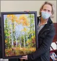  ?? BARB AGUIAR/Special to The Daily Courier ?? Jaxon Jurome, president of the Federation of Canadian Artists, Okanagan chapter, shows off Here We Stand, a framed 24-by 18-inch acrylic on canvas painted by Kit Bell that was raffled off on Saturday.