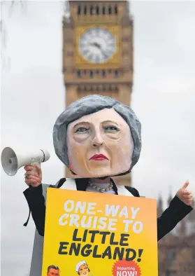  ?? Picture: AFP ?? UP IN ARMS. A demonstrat­or wearing a mask depicting Britain’s Prime Minister Theresa May protests against the United Kingdom’s triggering of Article 50, outside the Houses of Parliament in central London yesterday.