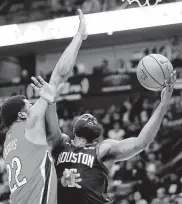  ?? Gerald Herbert / Associated Press ?? James Harden (der.) lanza frente a Derrick Favors en el triunfo de los Rockets el lunes, en Nueva Orleans.