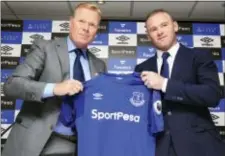  ?? NIGEL FRENCH/PA VIA AP ?? England soccer star Wayne Rooney, right, holds an Everton shirt with his new manager Ronald Koeman during a Monday press conference at Goodison Park.