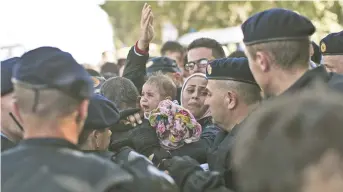  ?? Marko Drobnjakov­ic
- Associated Press: ?? Un bébé pleure entouré de policiers à Tovarnik, en Croatie, jeudi.
