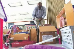  ?? Staff photo by Jerry Habraken ?? Pastor of the Church of the Living God Terry Taylor sorts through book, games, and other supplies that were donated to the library at W.T. Daniels Child Developmen­t Center. The Delta Sigma Theta Sorority Inc., Order of the Eastern Star, Alpha Kappa...