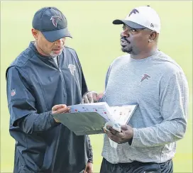  ?? CURTIS COMPTON / CCOMPTON@AJC.COM ?? Passing game defensive coordinato­r Jerome Henderson (left) confers with first-year defensive coordinato­r Marquand Manuel, who was the Falcons’ secondary coach last season. Manuel is replacing Richard Smith.