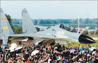  ?? WANG ZHENDONG / FOR CHINA DAILY ?? Visitors take photos of a fighter jet during an open day of the People’s Liberation Army Air Force in Changchun, Jilin province, on Thursday. The event featured aerobatics, skydiving and aircraft displays.