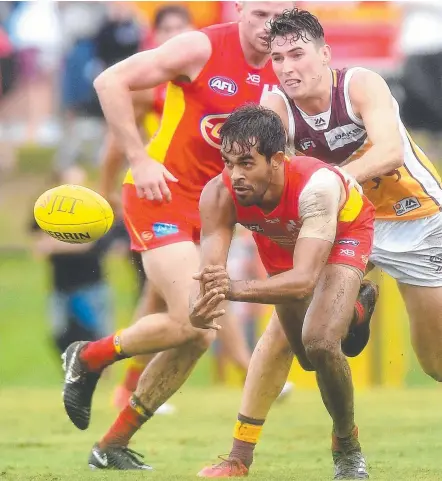  ?? Picture: GETTY IMAGES ?? Gold Coast’s Jack Martin gets a handball away against Brisbane at Southport on Sunday.