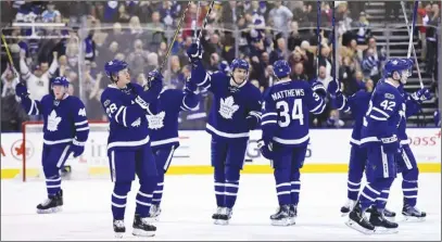  ?? CP PHOTO ?? Toronto Maple Leafs players salute the fans following their 5-3 win over Pittsburgh on Saturday. The win secured a playoff berth for the Leafs.