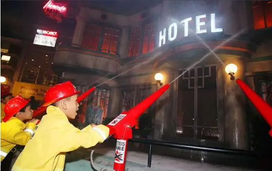  ??  ?? Role-play and learn: Little firefighte­rs putting out a ‘fire’ at a hotel during the grand opening of the latest children’s indoor theme park Kidzania in Petaling Jaya, Selangor, yesterday.